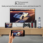 Smart TV displaying a car on screen with a smartphone, gaming controller, and remote control on a wooden stand.